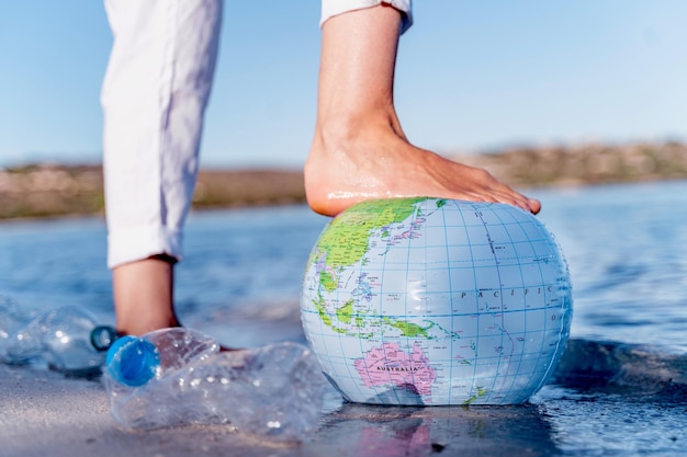 World Water Day Mans foot on Earth beach ball closeup