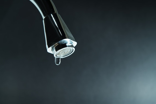 World water day, water drop on faucet with  black backgrounds