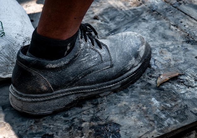worn black shoes made of leather and strong material covered with leather are used for field constru