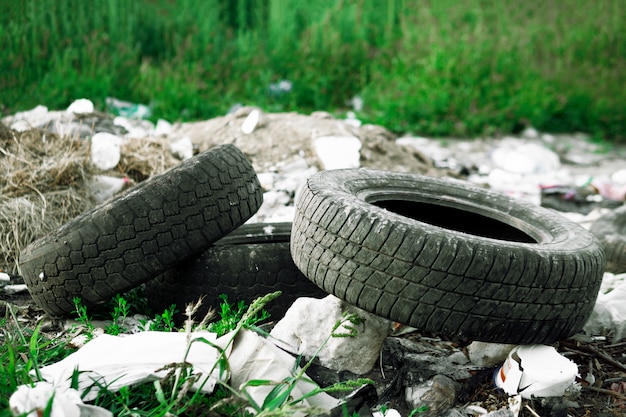 Photo worn car tires are lying in the trash. environmental pollution