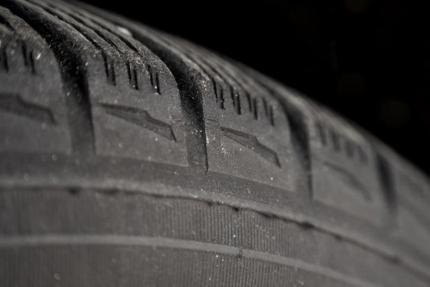 Worn tires macro Fissures on the black rubber tire Aged tyres closeup Cracked wheel safety risks Automotive service and maintenance