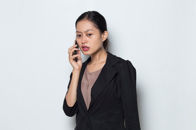 Worried asian business woman with mobile phone