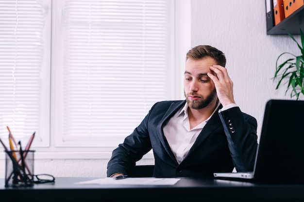 Uomo d'affari preoccupato che è interessato in ufficio. uomo d'affari dubbioso premuroso nel pensiero di tensione rende difficile la decisione sul lavoro,