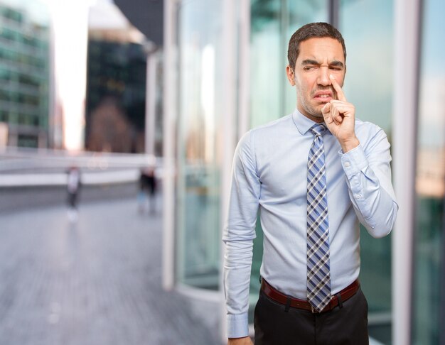 Worried businessman doing a bad smell gesture