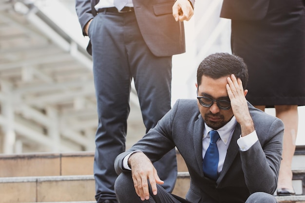 Worried businessman sitting outdoors