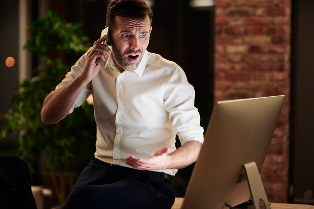 Worried businessman talking by mobile phone