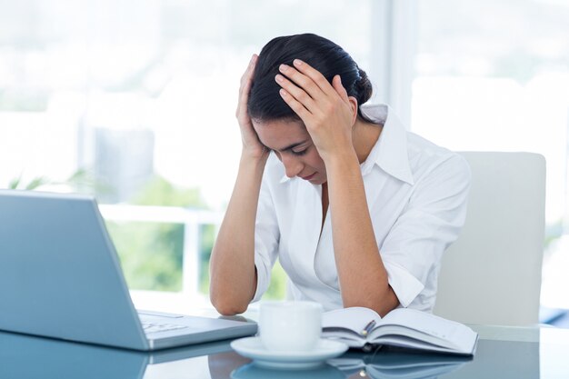 Worried businessman with head in hands 