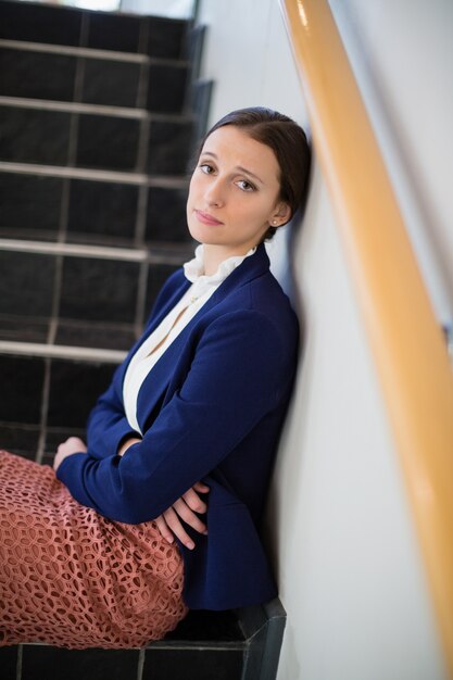 worried businesswoman sitting on steps