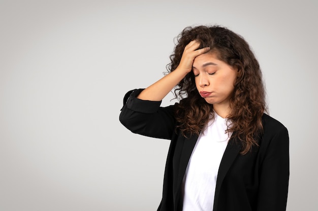 Worried businesswoman with hand on forehead