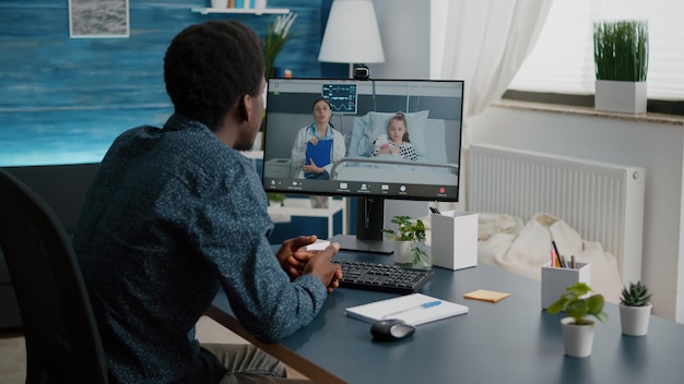 Worried dad for her little girl in hospital ward, talking with
doctor on video conference call using webcam app remote screen for
family connection. family doctor consultation via internet