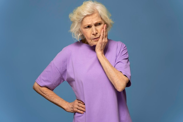 Photo worried grey hair caucasian woman with hand on hip looking away