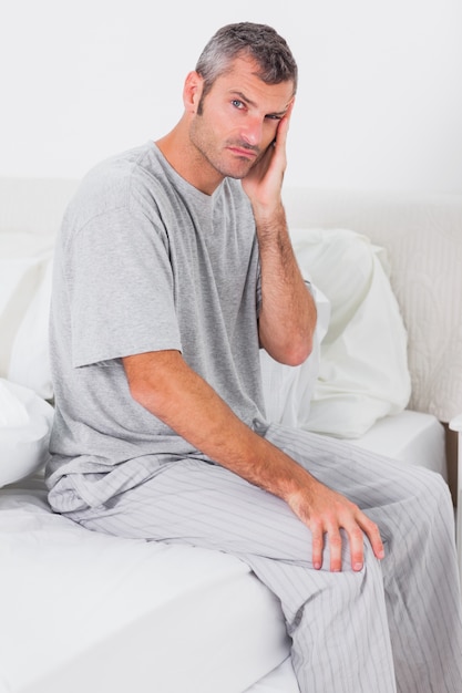 Worried man sitting in bed