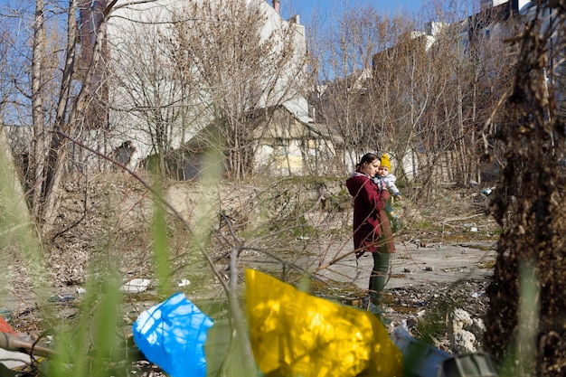 Madre preoccupata che guarda alla distruzione in una zona residenziale