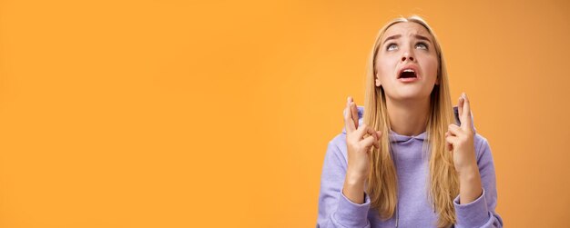 Foto donna bionda carina nervosa preoccupata in felpa con cappuccio che implorava dio aiuta incrociare le dita buona fortuna supplichevole gabinetto