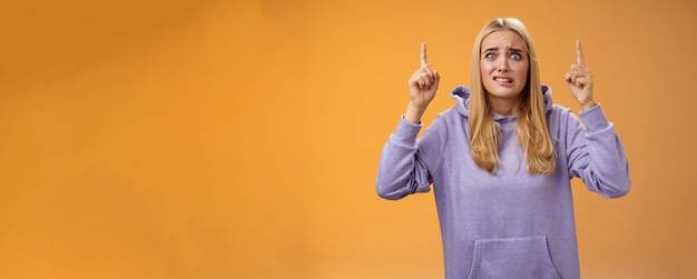 Worried perplexed unsure cute blond woman presenting project standing awkward afraid humiliation