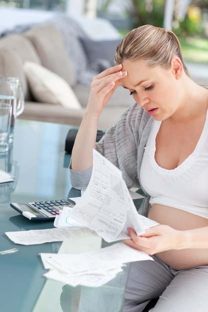 Worried pregnant woman calculating her domestic bills