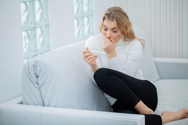 Worried sad woman Looking at a Pregnancy Test after result.