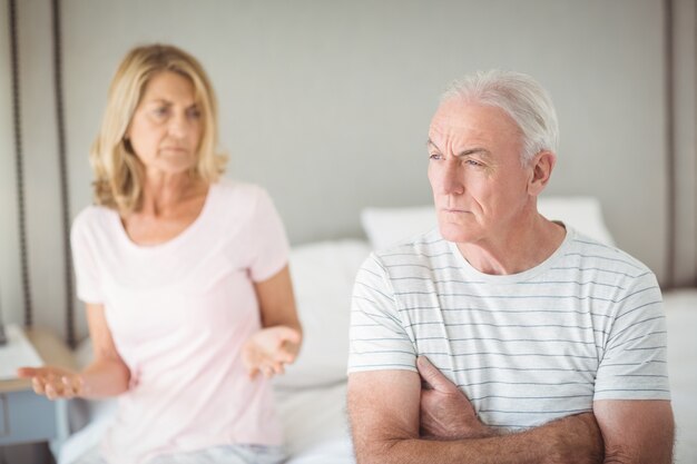 Worried senior man sitting on bed