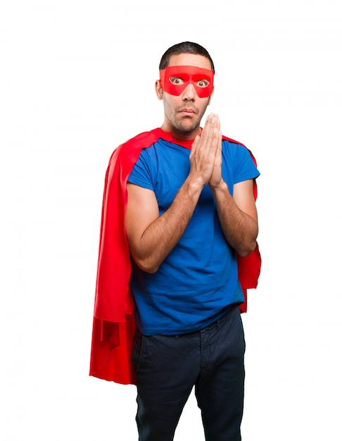 Worried superhero with a pray gesture