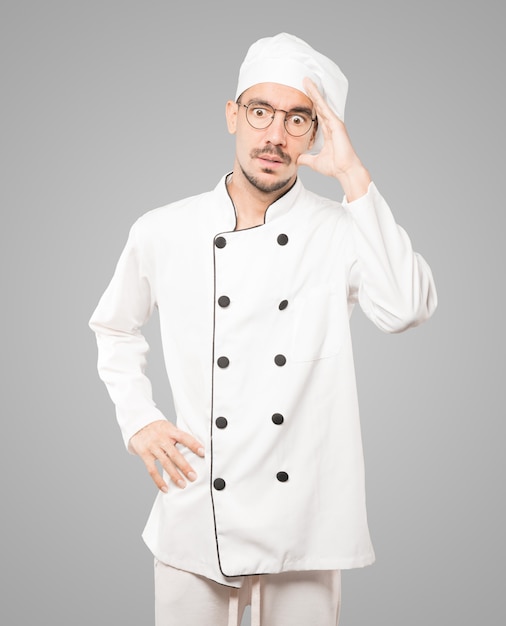 Worried young chef posing