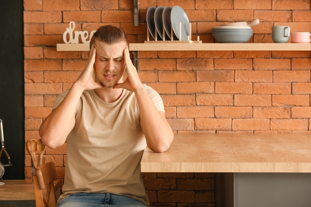 Worried young man in kitchen