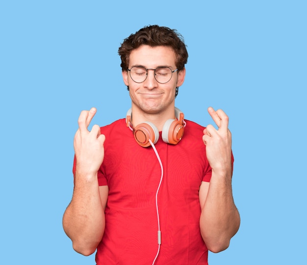 Worried young man making a fingers crossed gesture