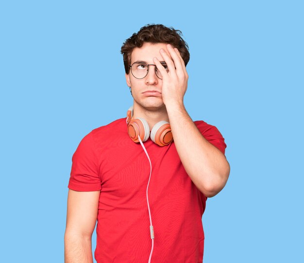 Worried young man using headphones