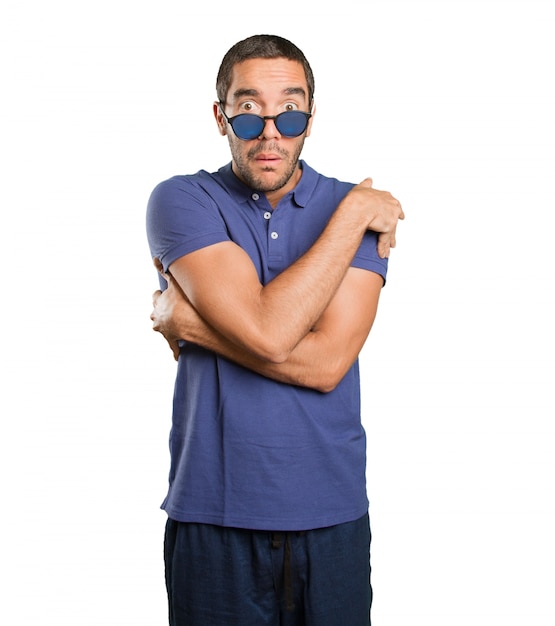 Worried young man with cold gesture on white background