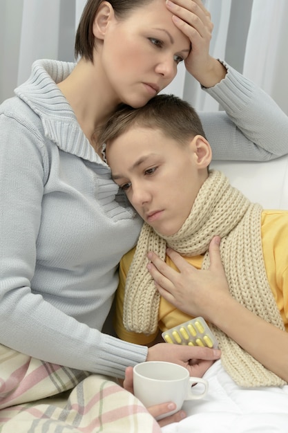 Worried Young mother and ill son in bed