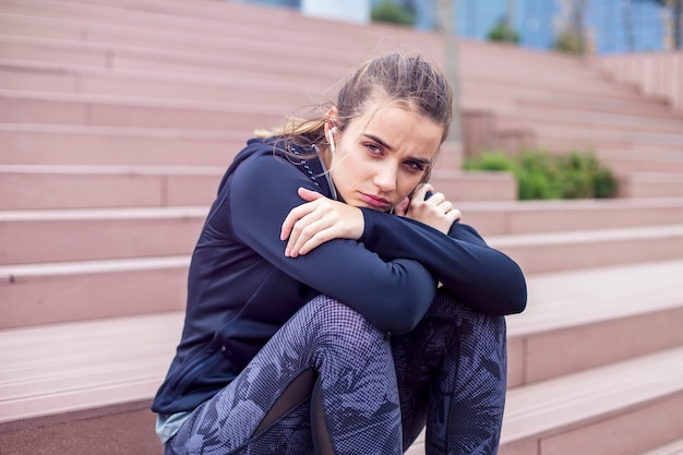 心配している若い女性が階段の外に座っています。