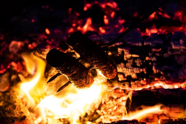 Worst barbecue bakken en koken met vuur vlammen en vet