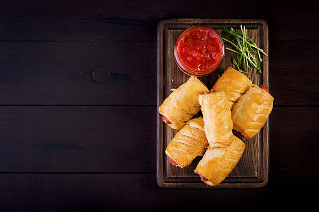 Worst in het deeg op een houten bord met tomatensaus.