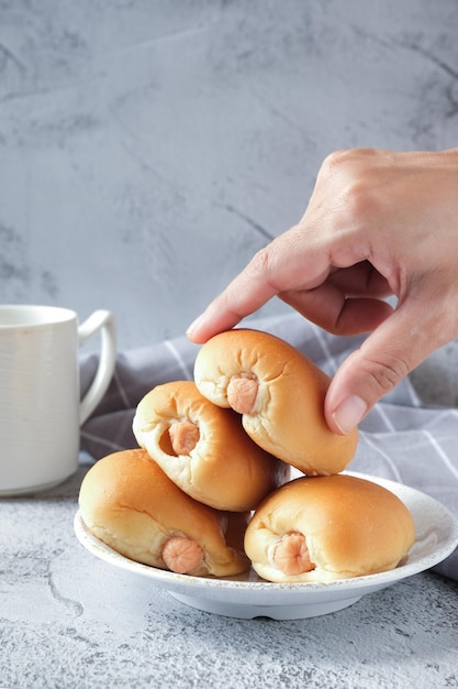 Worstbroodje en koffie met witte achtergrond overhandigen