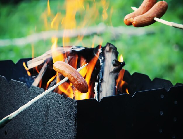 Worsten grillen voor een picknick buiten boven de vuurpot