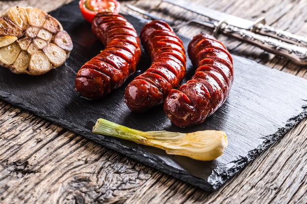 Worsten. Worsten grillen. Gegrilde worst met champignons knoflook tomaten en uien.