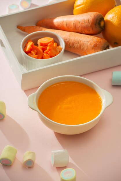 Wortel baby puree in kom geïsoleerd op lichte achtergrond