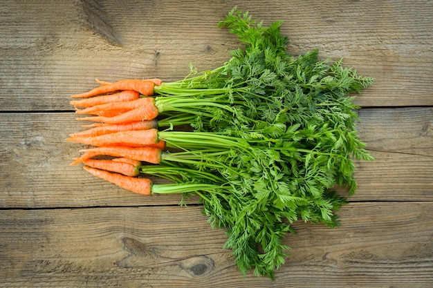 Wortel op houten tafel achtergrond Verse en zoete wortelen voor het koken van voedsel groenten en fruit voor gezondheidsconcept baby wortelen bos en blad