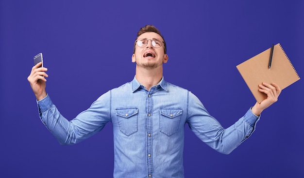 Wound professor with hands up in glasses, blue denim shirt screaming