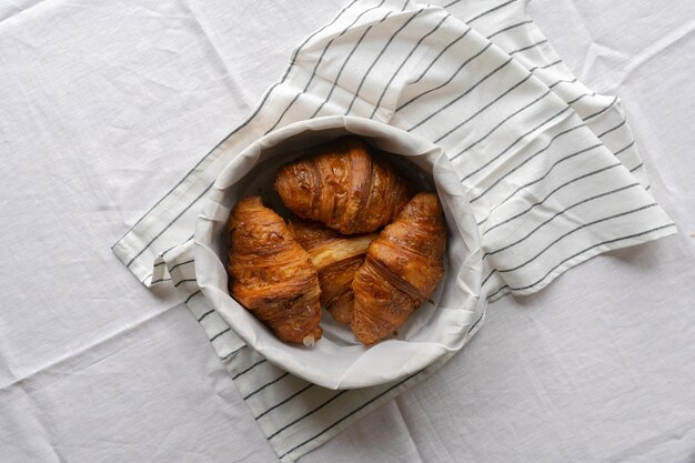 Photo woven basket of croissants on a table exuding rustic charm a delightful scene that captures the es