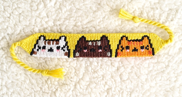 Woven DIY friendship bracelet with Cats pattern made of embroidery floss