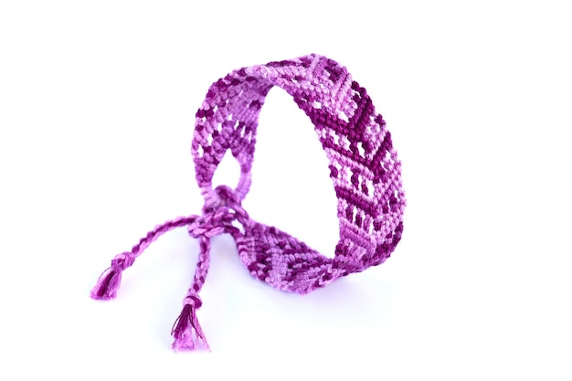 Woven DIY friendship bracelet with colorful pattern handmade of thread on white