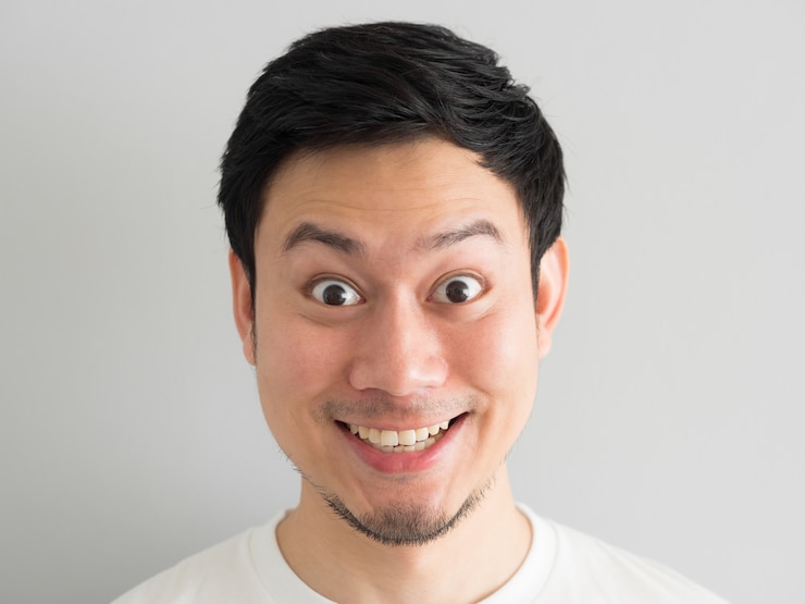 Photo ハッピーアジア人の頭のショットのうわーの顔。