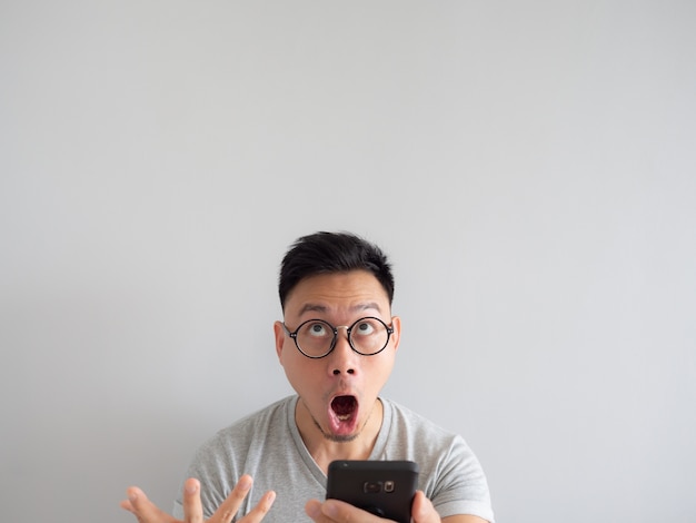 wow face of man shocked what he see in the smartphone.
