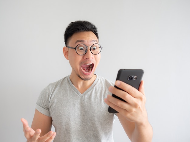 wow face of man shocked what he see in the smartphone.