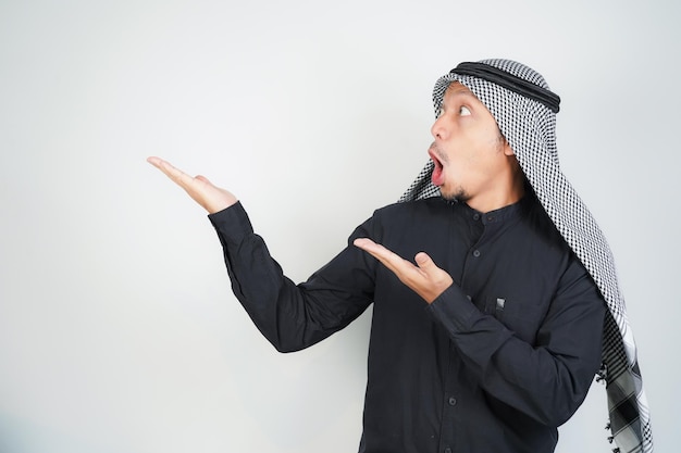 Photo wow face shocked expression asian muslim man wearing arab turban sorban pointing hand finger