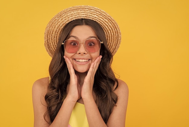 Wow finally summer holiday small beauty child wear straw hat and glasses amazed teen girl with curly hair on yellow background happy childrens day kid summer fashion beach party