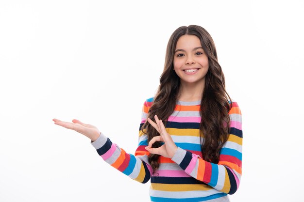 Wow it's unbelievable Shocked teenager child pointing aside at copy space Teen girl pointing with two hands and fingers to the side Happy girl face positive and smiling emotions