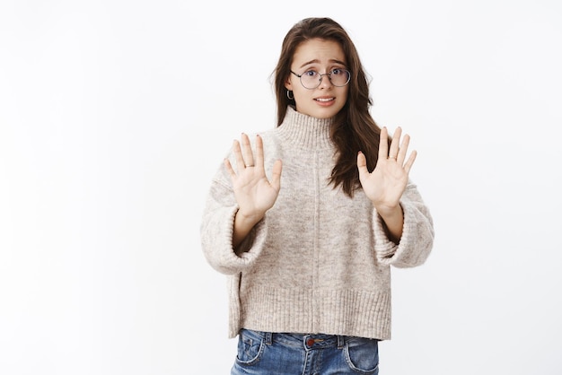 Wow no grazie intensa ragazza bruna scontenta e nervosa con gli occhiali e maglione che fa un passo indietro e agita le mani in segno di rifiuto accigliata suggerimento di antipatia rifiutando un'offerta sospetta