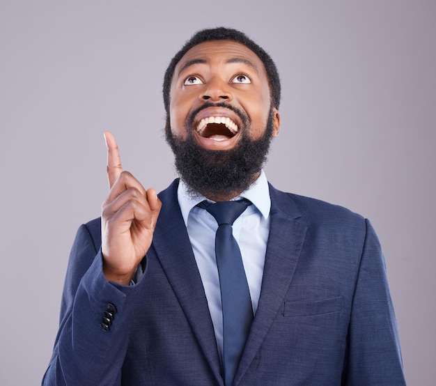 wow pointing and promotion with a business black man in studio on a gray background for motivation winner hand gesture and announcement with a corporate male employee celebrating success
