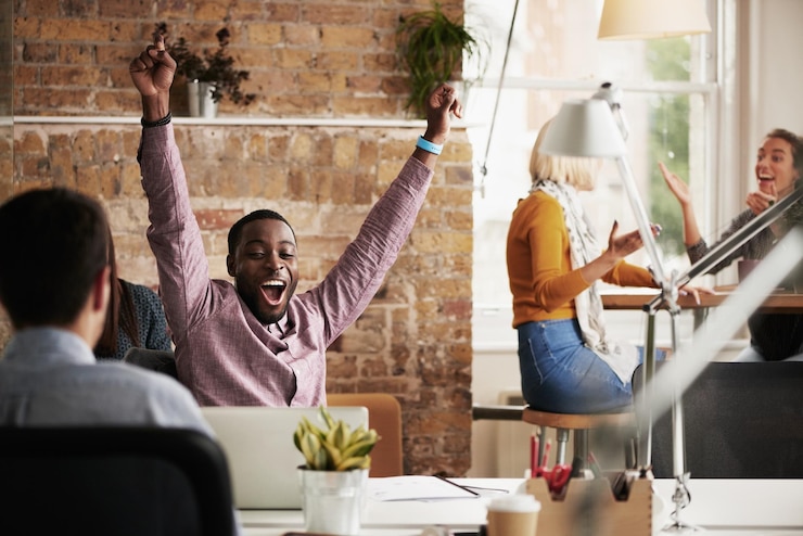 Photo wow success and black man in happy celebration at work after sales goals or reaching target in an office job promotion winner or excited employee with arms in the air to celebrate winning a deal